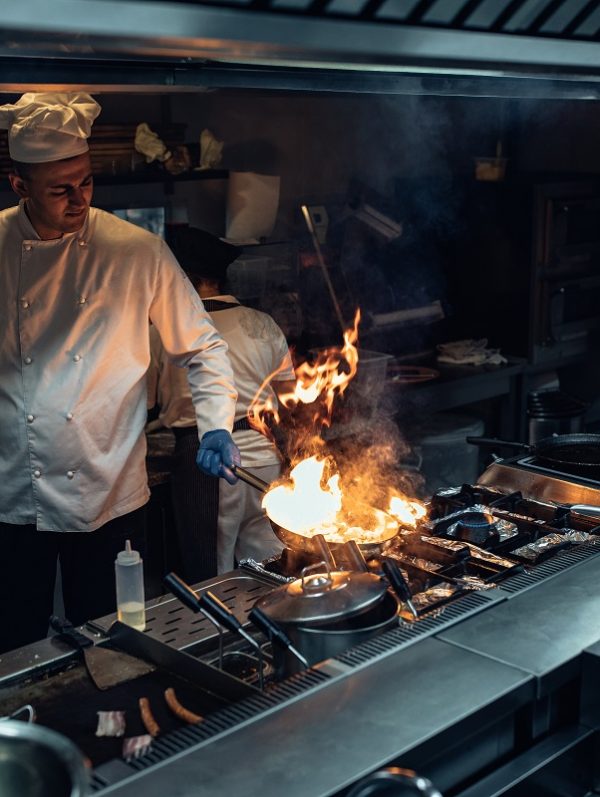 Chef preparing a meal using fire in the professional kitchen